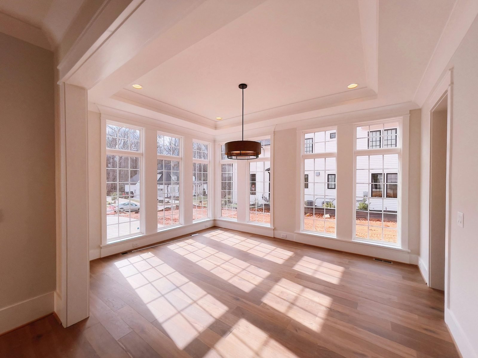 Sunlit room with beautiful floor-to-ceiling windows and warm hardwood floors